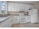 White kitchen with modern appliances, tile floor and granite countertops at 216 Earl St, Daytona Beach, FL 32118