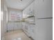 Efficient kitchen design with white appliances, tile floors, ample counter space, and natural light from a window at 216 Earl St, Daytona Beach, FL 32118