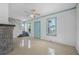 Spacious living room with tile floors, a gray brick fireplace, a ceiling fan, and stair access at 216 Earl St, Daytona Beach, FL 32118