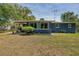 Cozy single story home with a backyard featuring a covered patio, lush lawn, and mature trees at 220 Buena Vista St, Debary, FL 32713