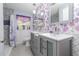 Charming bathroom featuring floral wallpaper, dual sinks, updated vanity, and tub shower with decorative tile surround at 220 Buena Vista St, Debary, FL 32713