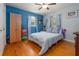 Bright bedroom with hardwood floors, a large closet, and blue walls; perfect for relaxation and comfort at 220 Buena Vista St, Debary, FL 32713
