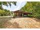 The property includes a spacious carport with a car parked underneath, surrounded by greenery and trees at 220 Buena Vista St, Debary, FL 32713