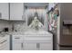 Bright kitchen sink with marble countertops, stainless steel appliances, and white cabinets at 220 Buena Vista St, Debary, FL 32713