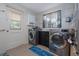 Functional laundry room featuring modern washer and dryer, cabinet storage, and a door to the outdoors at 220 Buena Vista St, Debary, FL 32713