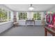 Bright sun room with large windows, neutral carpet, and stylish furniture; perfect for relaxing and enjoying the view at 220 Buena Vista St, Debary, FL 32713