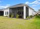 Rear exterior view of home featuring a screened in lanai and well maintained lawn at 225 Mosaic Blvd, Daytona Beach, FL 32124
