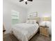 Cozy bedroom featuring a comfortable bed, soft lighting, and a large window at 225 Mosaic Blvd, Daytona Beach, FL 32124