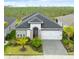 Charming single-story home featuring a manicured front yard and an attached two-car garage with an attractive paved driveway at 225 Mosaic Blvd, Daytona Beach, FL 32124