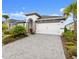 Inviting single-story home showcasing a paved driveway, tidy landscaping, and an attached two-car garage at 225 Mosaic Blvd, Daytona Beach, FL 32124