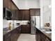 Contemporary kitchen with stainless steel appliances, dark cabinets, granite countertops, and ample counter space at 225 Mosaic Blvd, Daytona Beach, FL 32124