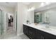 Modern bathroom with double vanity, sleek black cabinets, framed mirror, and walk-in closet access at 2337 Oxmoor Dr, Deland, FL 32724