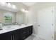 Bright bathroom with double vanity, black cabinets, a framed mirror, and ample natural light through the window at 2337 Oxmoor Dr, Deland, FL 32724