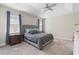 Bright bedroom featuring a tray ceiling, ceiling fan, and large windows with elegant blue patterned curtains at 2337 Oxmoor Dr, Deland, FL 32724