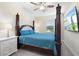Cozy bedroom with a four-poster bed, a ceiling fan, a white nightstand, and a mounted television at 2337 Oxmoor Dr, Deland, FL 32724
