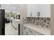 Modern kitchen with white cabinetry, stone countertops, stainless steel appliances, and an open layout at 2337 Oxmoor Dr, Deland, FL 32724