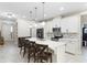 Well-lit kitchen features white cabinets, stainless steel appliances, a mosaic backsplash, and a large center island with barstool seating at 2337 Oxmoor Dr, Deland, FL 32724