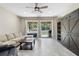 Bright living room features comfortable seating, ceiling fan, backyard access, and an entertainment center at 2337 Oxmoor Dr, Deland, FL 32724