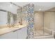 Chic bathroom featuring patterned wallpaper, marble countertops, a glass-enclosed shower and tub at 241 Riverside Dr # 902, Holly Hill, FL 32117