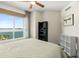 Comfortable bedroom with a view of the city and the sea, featuring a ceiling fan and ample natural light at 241 Riverside Dr # 902, Holly Hill, FL 32117