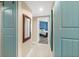 Hallway view with blue doors and a glimpse into a well-lit bedroom with stylish decor at 241 Riverside Dr # 902, Holly Hill, FL 32117