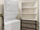 Efficient laundry area with a stacked washer and dryer and shelving units to maximize storage and organization at 241 Riverside Dr # 902, Holly Hill, FL 32117