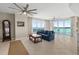Bright living room featuring a comfortable blue sofa, ceiling fans, and stunning waterfront views at 241 Riverside Dr # 902, Holly Hill, FL 32117