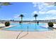 Stunning community pool with clear blue water, beautiful landscaping, and city views with multiple palm trees around at 241 Riverside Dr # 902, Holly Hill, FL 32117