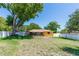 Large backyard with healthy lawn, mature trees, and a white privacy fence at 242 Linda Vista St, Debary, FL 32713