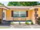 Close-up of home's facade with window planters, front door, and tidy garden bed at 242 Linda Vista St, Debary, FL 32713