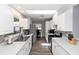 Well-lit galley kitchen with white cabinets, stainless steel appliances, and sleek countertops at 242 Linda Vista St, Debary, FL 32713
