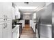 Galley kitchen showcasing white cabinetry, stainless steel appliances and modern design at 242 Linda Vista St, Debary, FL 32713