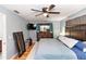 Spacious bedroom with wood floors, ceiling fan, TV, and view of a dark wood dresser with mirror at 242 Linda Vista St, Debary, FL 32713