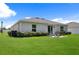 Expansive backyard showcasing lush green lawn, patio seating, and privacy bushes at 2518 Hoptree Ln, Edgewater, FL 32141