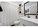 Clean bathroom with a white vanity, white cabinets, matte black hardware and a shower with curtain at 2518 Hoptree Ln, Edgewater, FL 32141