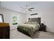 Cozy bedroom with a rustic wooden headboard, neutral walls, and a view of a large window at 2518 Hoptree Ln, Edgewater, FL 32141