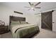 Spacious bedroom with a barn door leading to the bathroom, complemented by a rustic headboard at 2518 Hoptree Ln, Edgewater, FL 32141