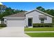 Charming single Gathering home with a well-maintained lawn, concrete driveway, and a two car garage at 2518 Hoptree Ln, Edgewater, FL 32141