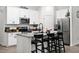 Modern kitchen featuring white cabinets, a kitchen island with seating, stainless steel appliances, and dark countertops at 2518 Hoptree Ln, Edgewater, FL 32141