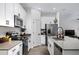 Modern kitchen featuring white cabinets, stainless steel appliances, and dark countertops overlooking the living area at 2518 Hoptree Ln, Edgewater, FL 32141