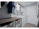 Modern laundry room with front load washer/dryer, storage cabinets, and folding table at 2518 Hoptree Ln, Edgewater, FL 32141
