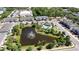 Aerial view of community with ponds, a pool, and a clubhouse surrounded by landscaping and lush trees at 258 Rustic Loop, Sanford, FL 32771