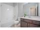 Bright bathroom featuring a white tile shower, dark vanity with countertop, and modern fixtures at 258 Rustic Loop, Sanford, FL 32771