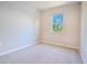 Sunlit bedroom with neutral walls, carpet, and window offering a view of nature at 258 Rustic Loop, Sanford, FL 32771