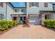 Townhome showcasing brick driveway, landscaping, and an attached garage at 258 Rustic Loop, Sanford, FL 32771