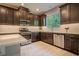 Modern kitchen with stainless steel appliances, dark cabinetry, white countertops, and tile backsplash at 258 Rustic Loop, Sanford, FL 32771