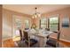Inviting dining area with a farmhouse table set for a meal, illuminated by a modern chandelier at 2628 Spruce Creek Blvd, Port Orange, FL 32128