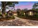 Lovely one-story home with inviting circular driveway, lush landscaping, and evening sky at 2628 Spruce Creek Blvd, Port Orange, FL 32128