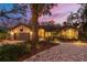 Charming home with lush landscaping, brick driveway, and warm exterior lighting at 2628 Spruce Creek Blvd, Port Orange, FL 32128