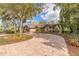 Charming one-story home with a circular driveway, lush landscaping and mature trees at 2628 Spruce Creek Blvd, Port Orange, FL 32128